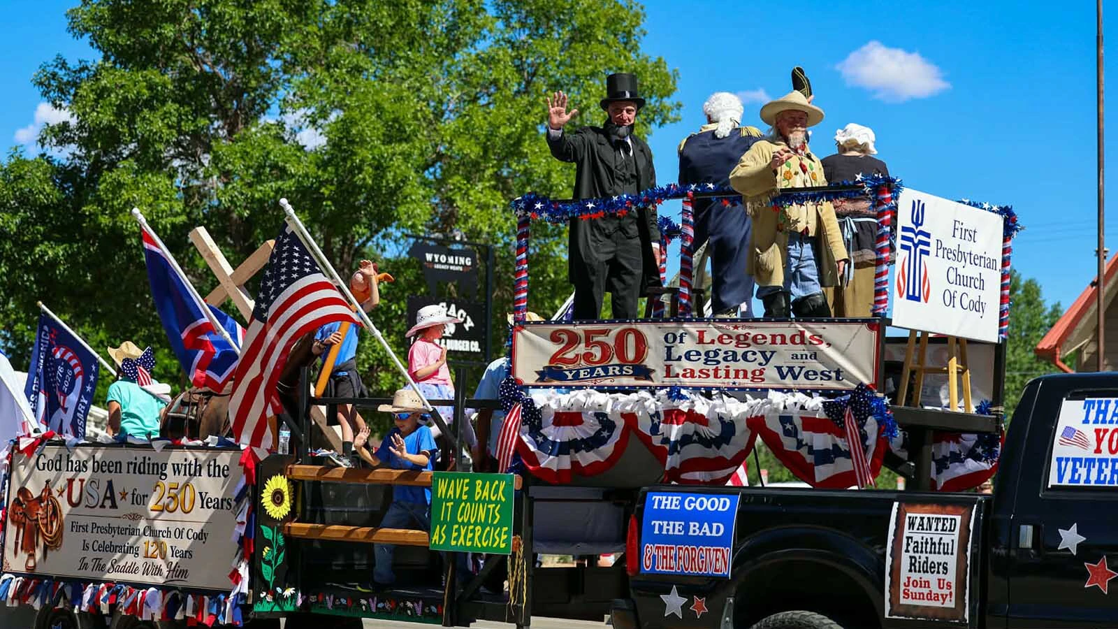 Buffalo Bill, Abraham Lincoln, George Washington, and Betsy Ross wave from a float celebrating America's 250th birthday in the 2026 Cody Stampede Parade.