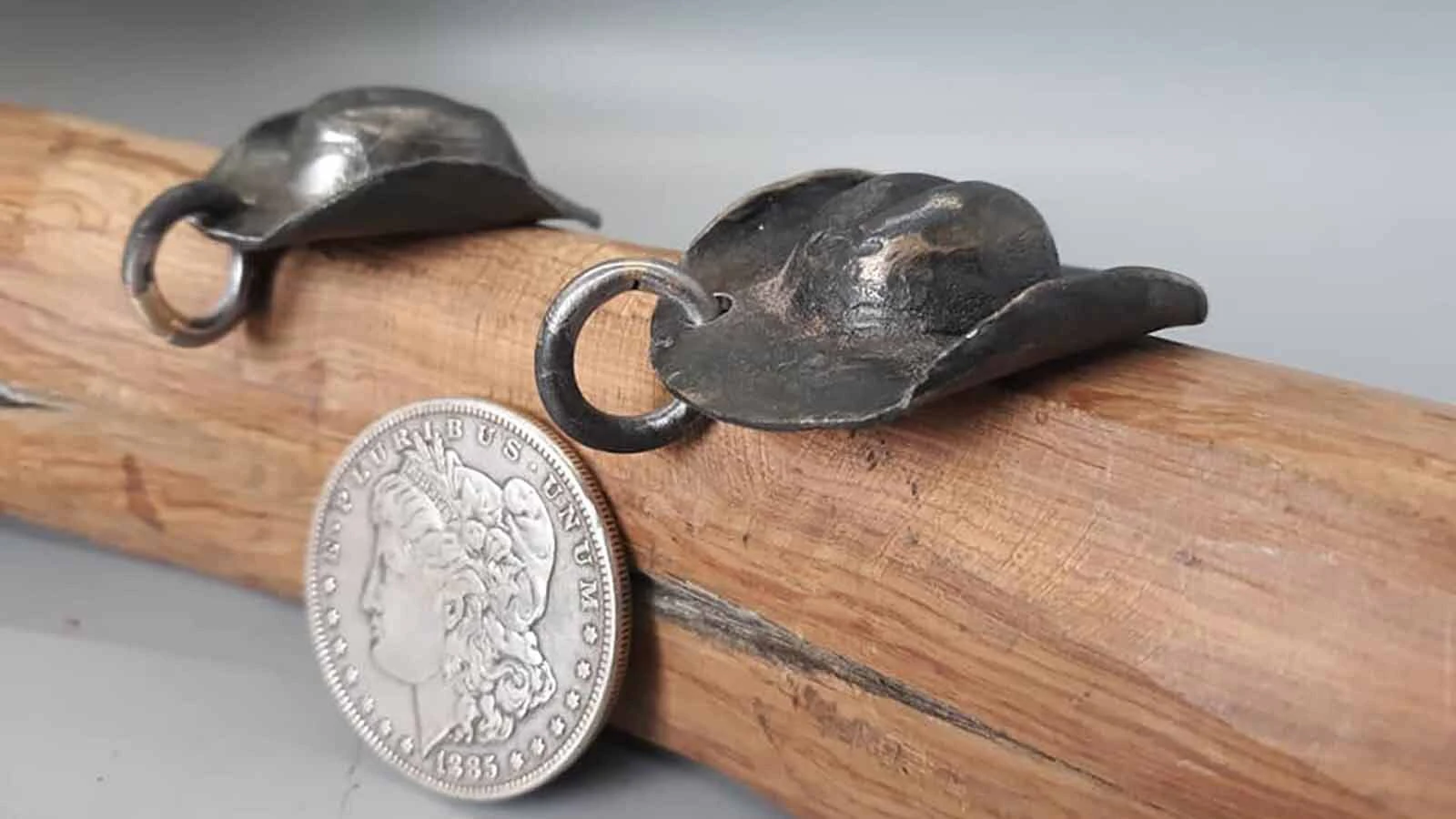 A pair of tiny cowboy hat charms.