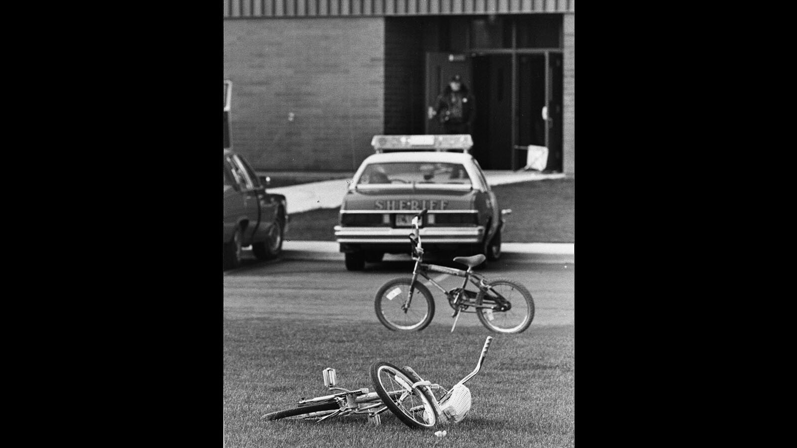 Children's bikes rest in the grass outside of the Cokeville Elementary School as police investigate the aftermath of a hostage situation and bombing May 16, 1986.