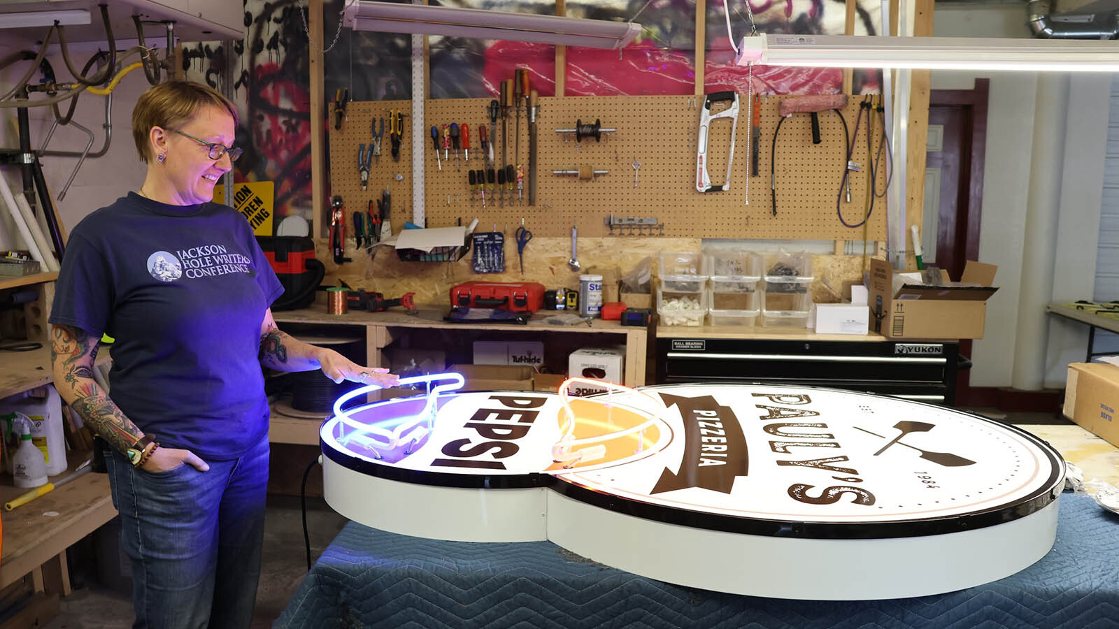 Connie Morgan shows of a sign she created for a pizza place in South Dakota.