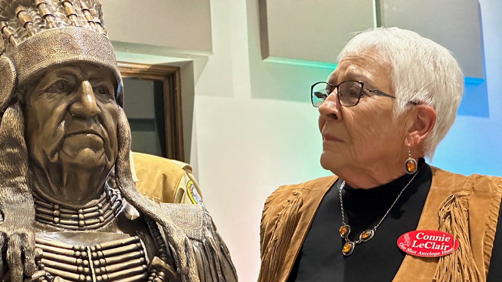 Connie LeClair stands beside the bust of her husband, Willie LeClair, who was honored after his unfortunate passing by the One Shot Antelope hunt committee.