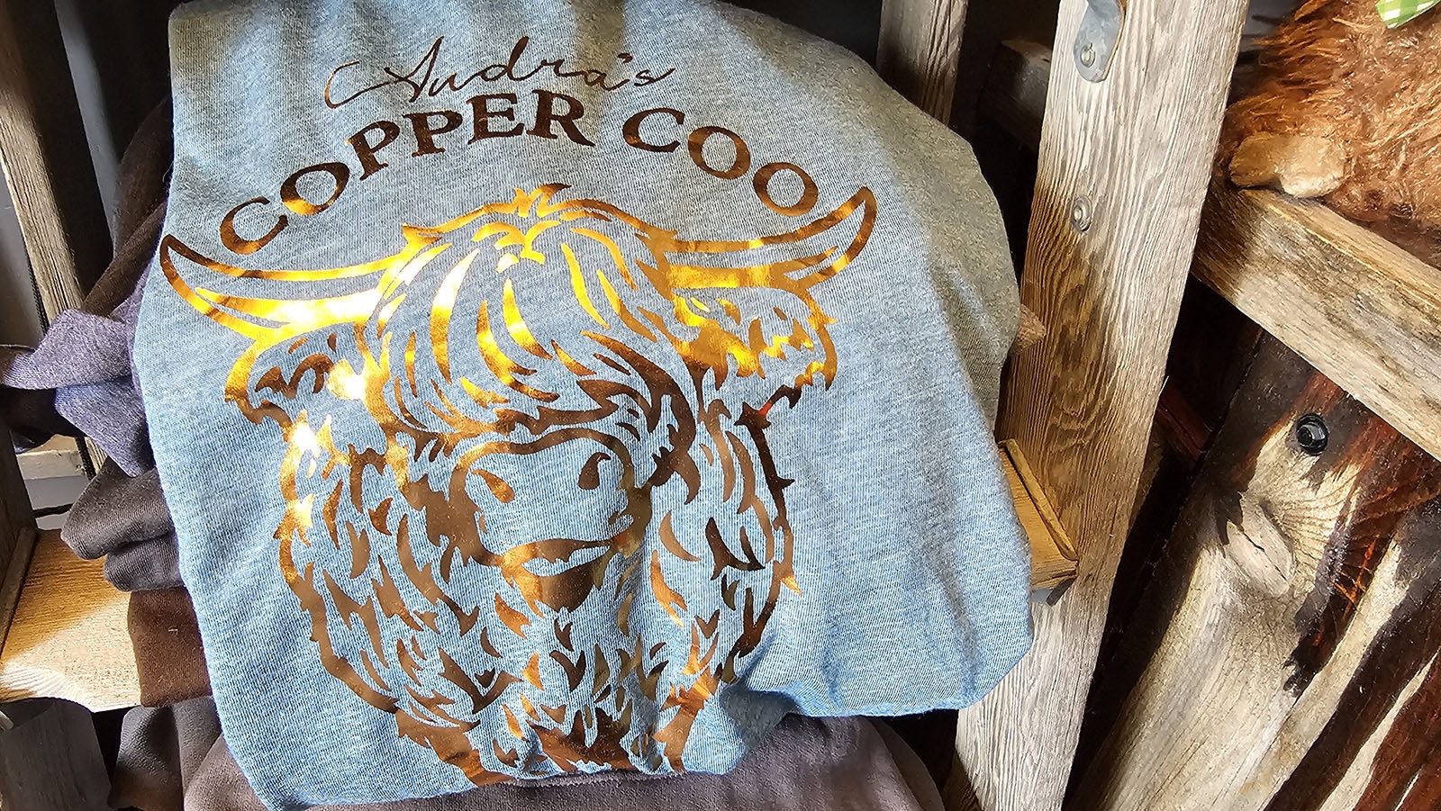 Scottish Highland coo are all over the walls, and all over the T-shirts and other items for sale at Audra Dominguez's coffee shop.