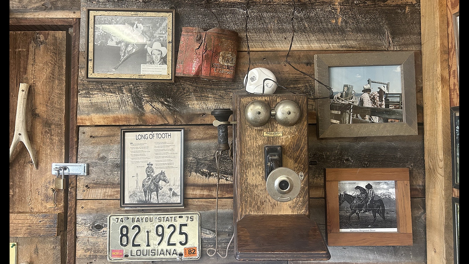 Photographs and an old telephone hang from the wall in the Cora Post Office.
