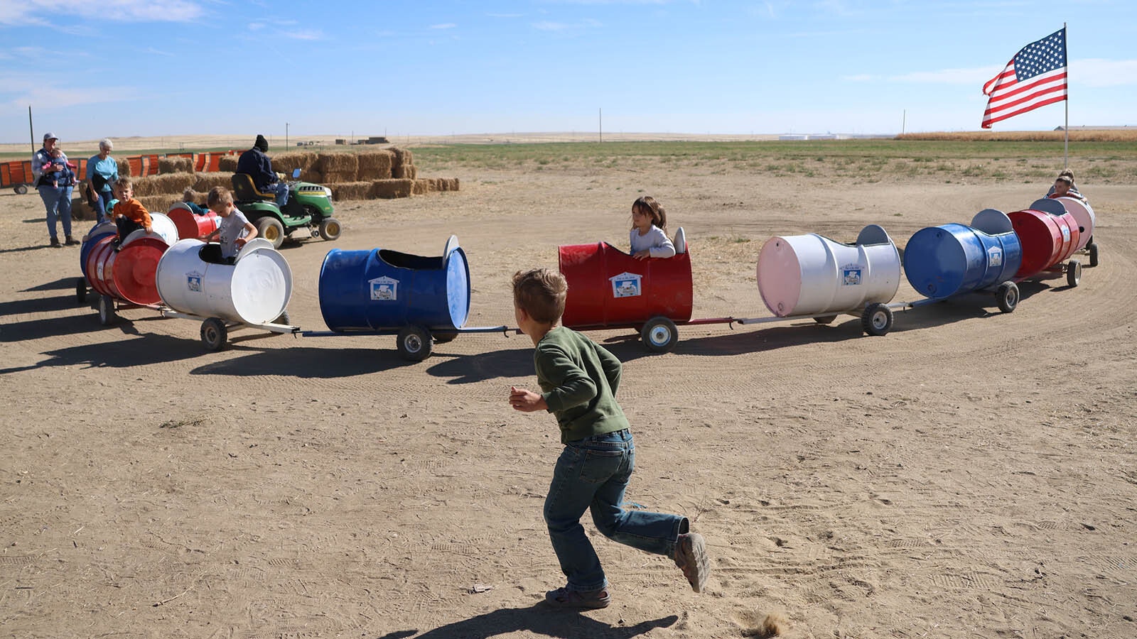 A barrel-cart train pulled by a riding lawnmower is a popular attraction for kids at the Green Acres Corn Maze.