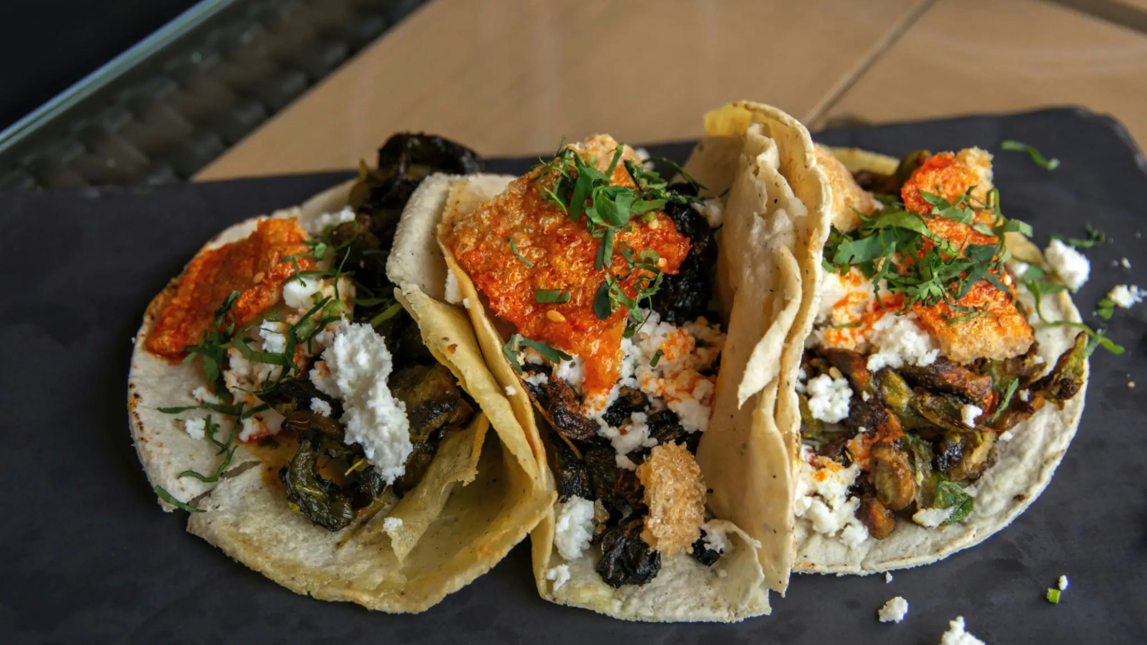 A trio of tacos featuring huitlachoche, aka "corn smut," prepared different ways.