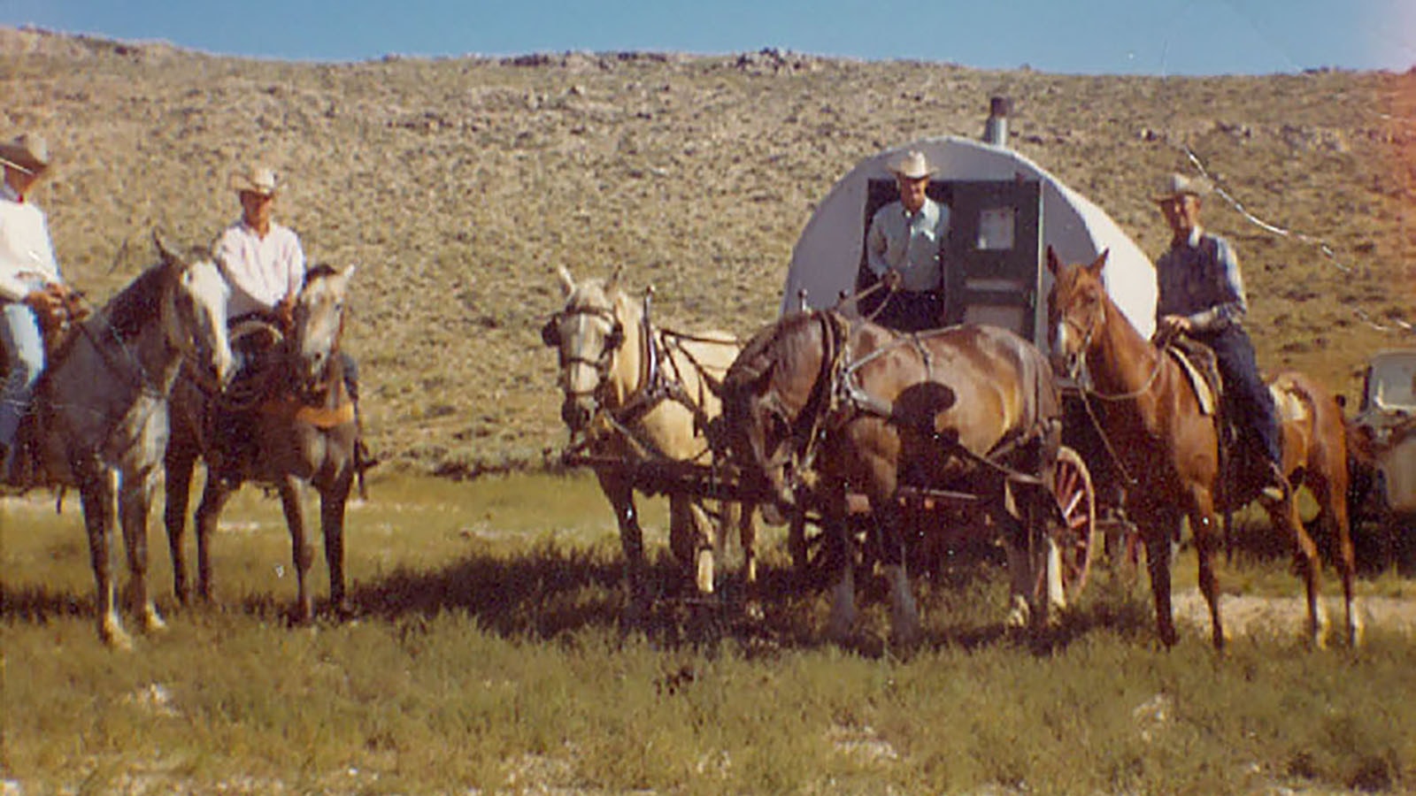 Frank Miller and others with a wagon while working his family's Carbon County ranch.