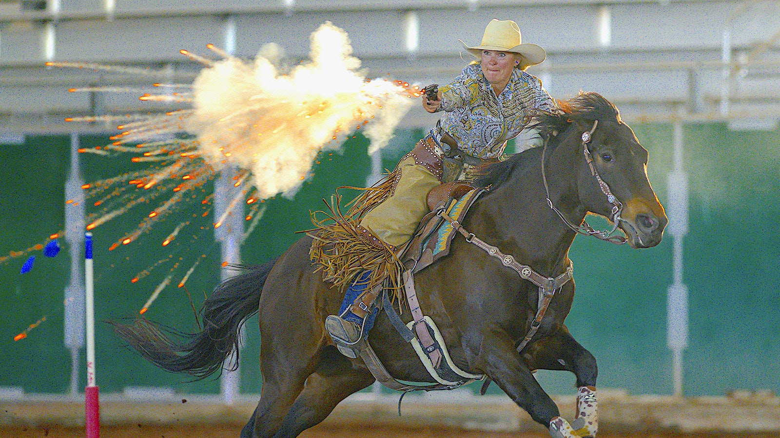Sparks fly from the black powder explosion used by Kendra Lenseigne during cowboy mounted shooting competition.