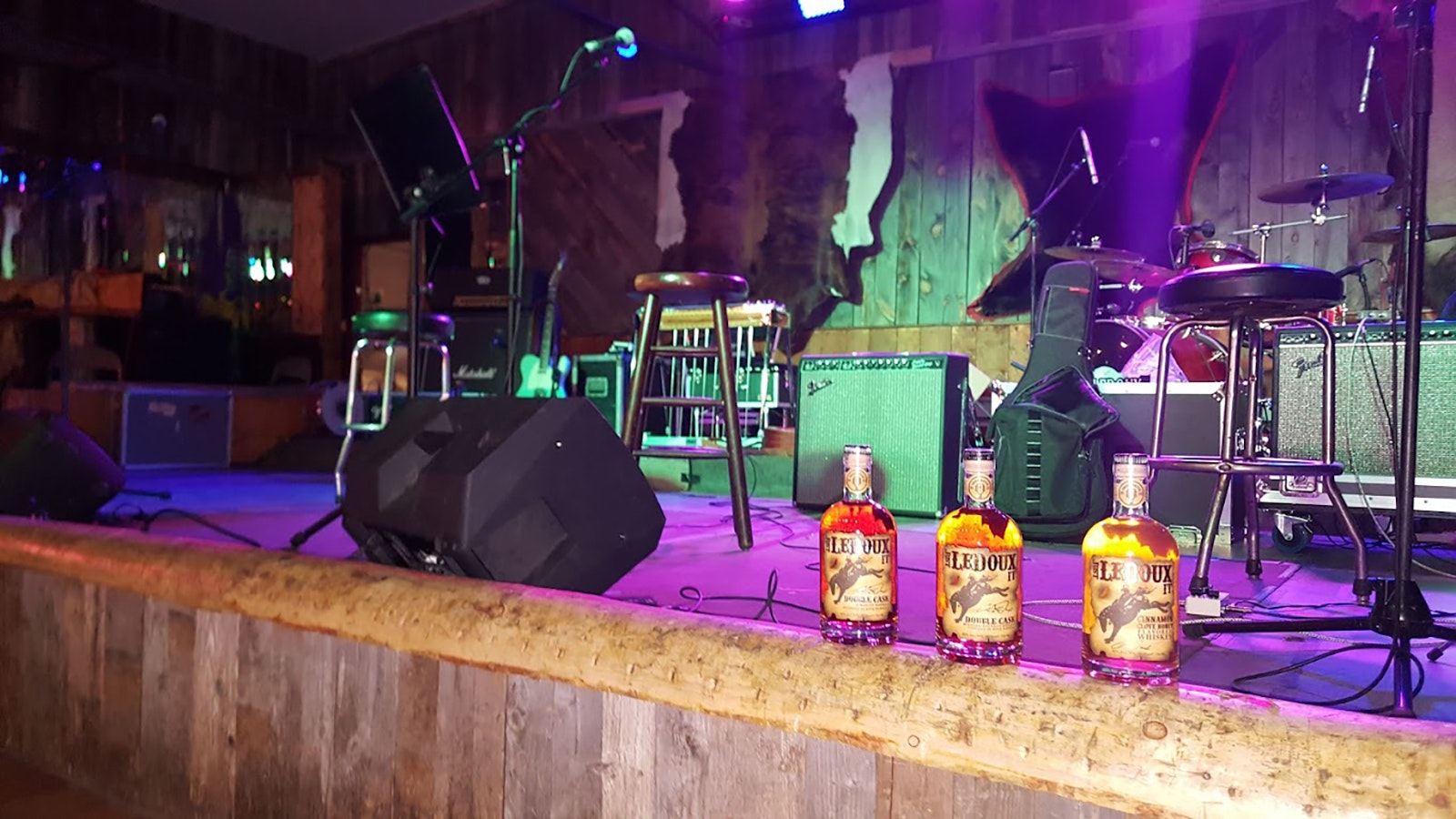 Bottles of Just Ledoux It whiskey on the edge of the stage at the Cowboy Saloon & Dance Hall.