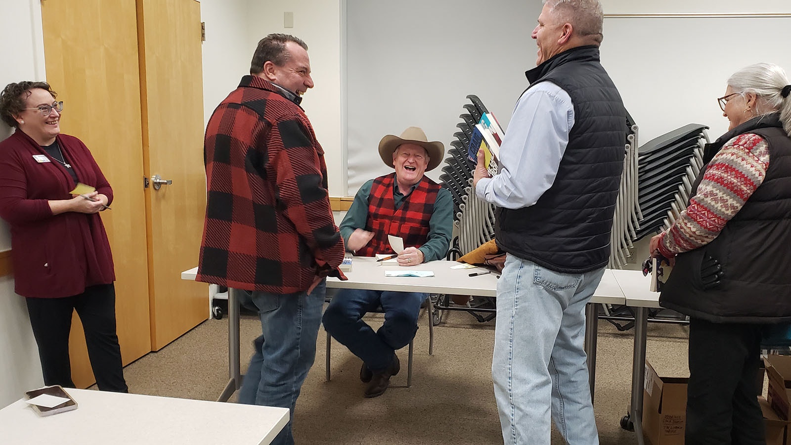Laramie County Sheriff Brian Kozak, left, and DeputyTim Cameron laugh with Craig Johnson at one of the author's jokes. They were among those with an armful of books to sign after a recent short story reading for Johnson's annual Christmas tour.