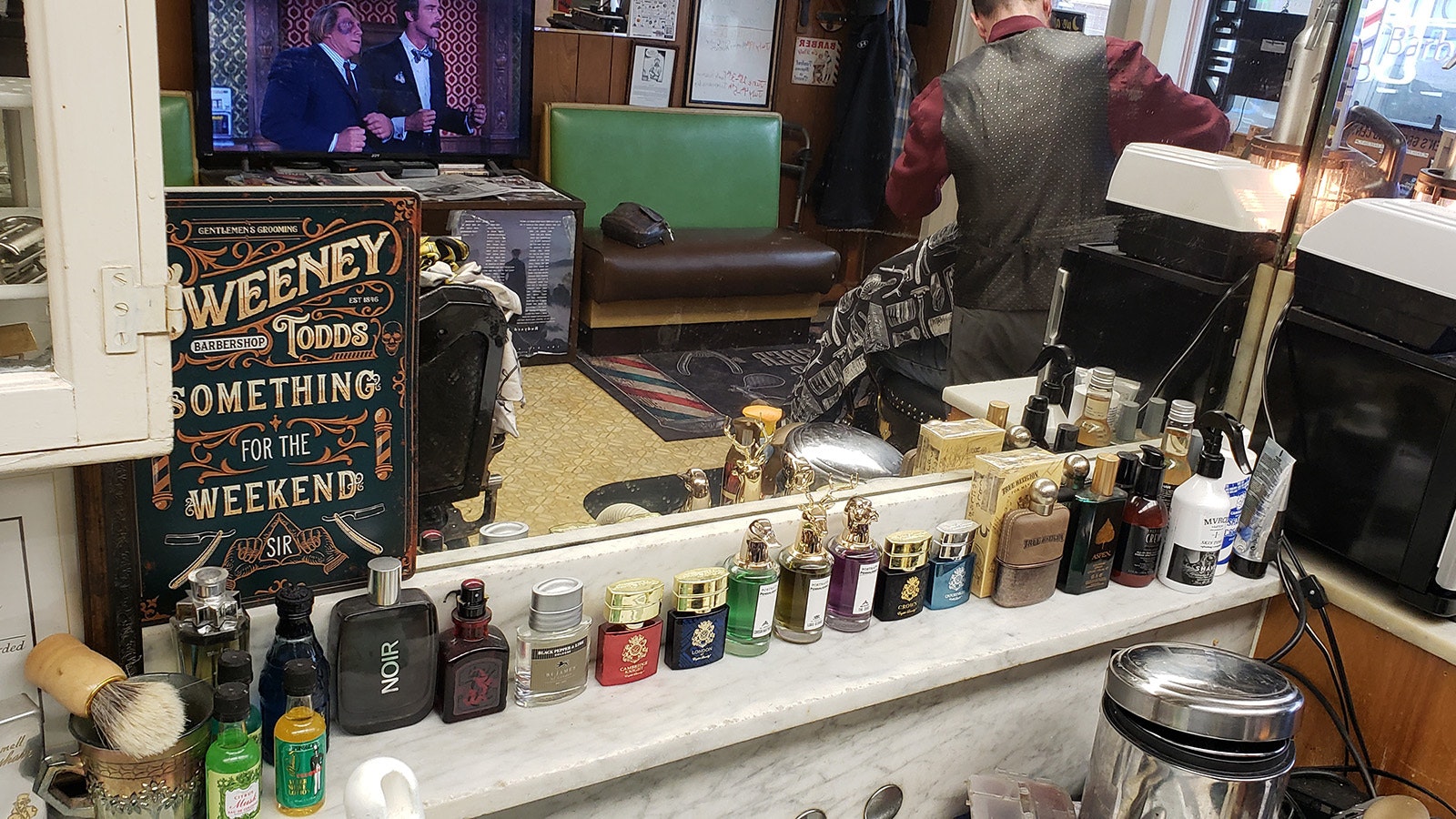 Customers bring old Avon bottles and shaving cups to display at Kurt's Cuts.