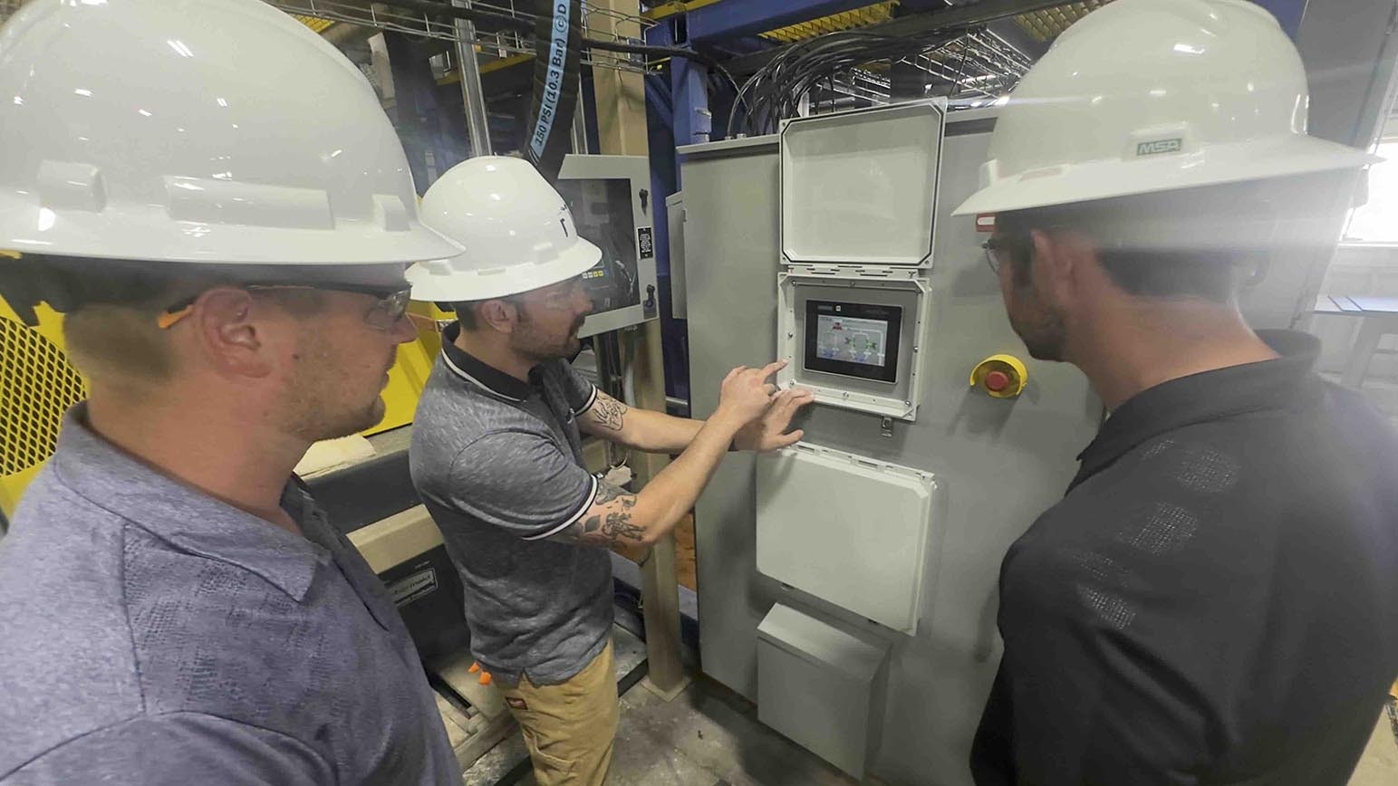 Chase Dickinson demonstrates a control panel at DISA Technologies for co-founders John Lee, left, and Greyson Buckingham.