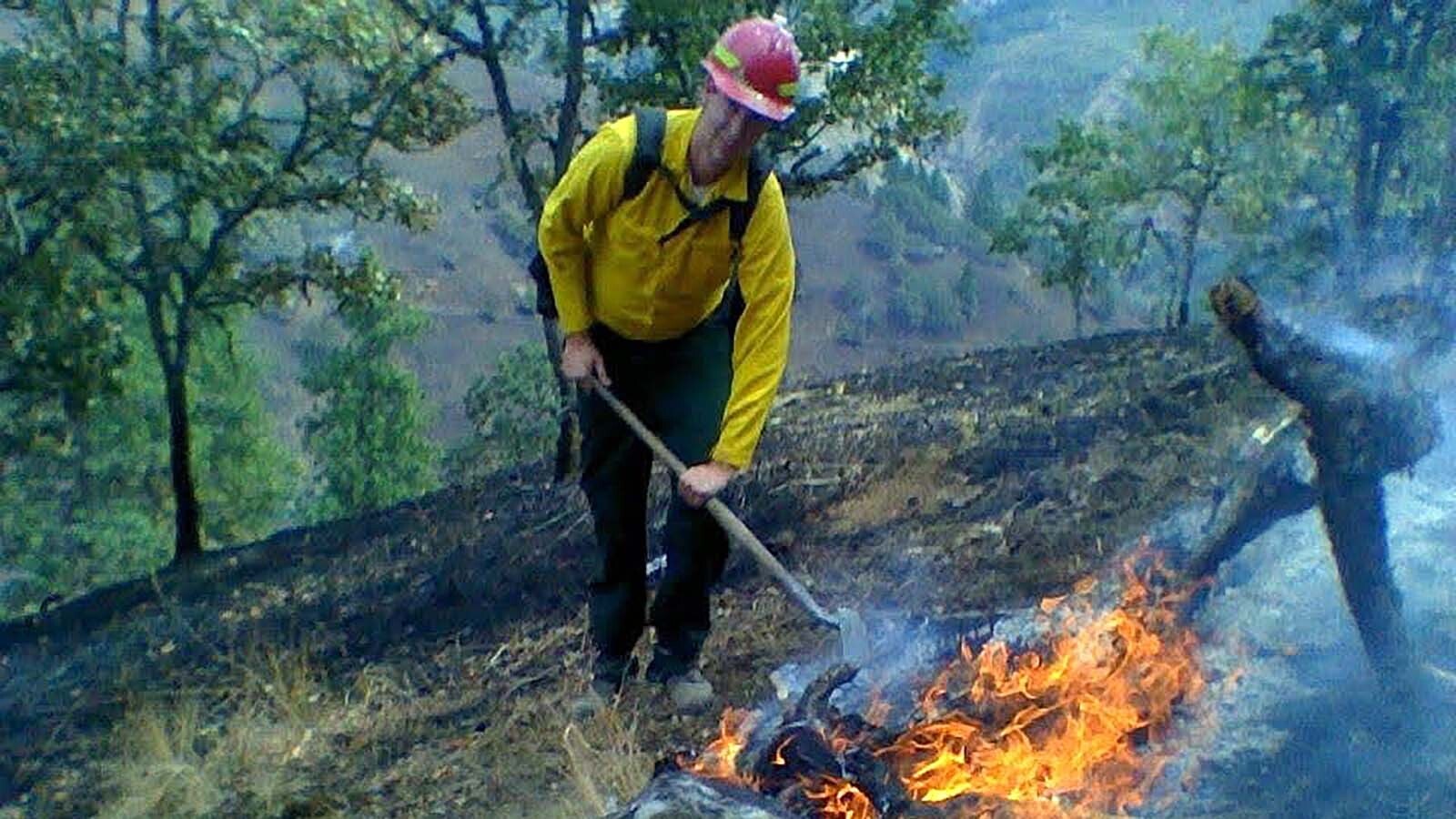 Darren Clifford of Lander, Wyoming, works on a fire in Okanogan, Washington. Now 42, he needs a lung transplant from the smoke inhalation, but has a passion for working with wildland fire, just now he does it virtually. He began a Facebook page sharing photos and video on his page, Caught The Fire Bug.