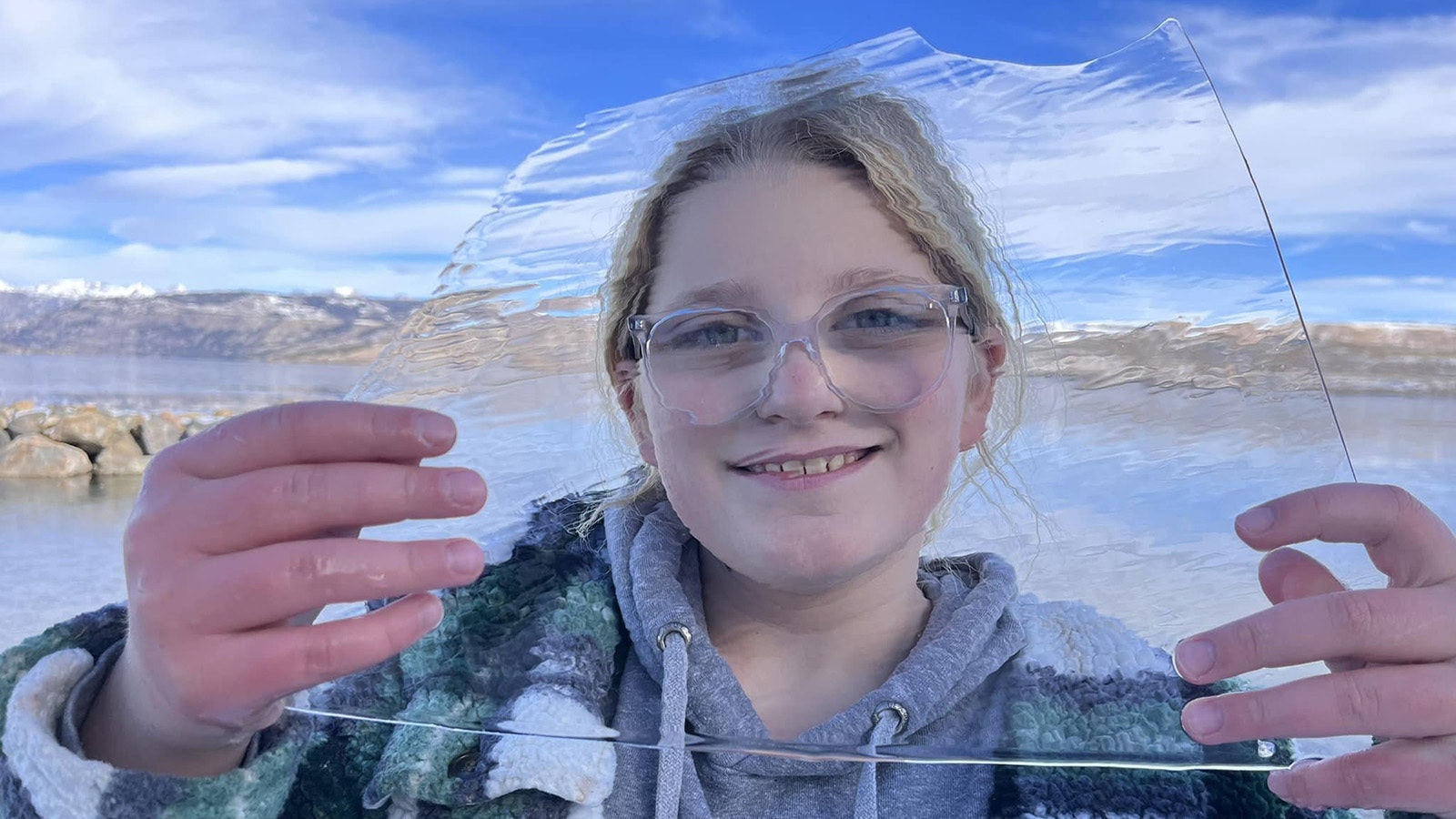 Dave Bell's granddaughter Rory looks through a perfectly clear, clean piece of Fremont Lake ice.