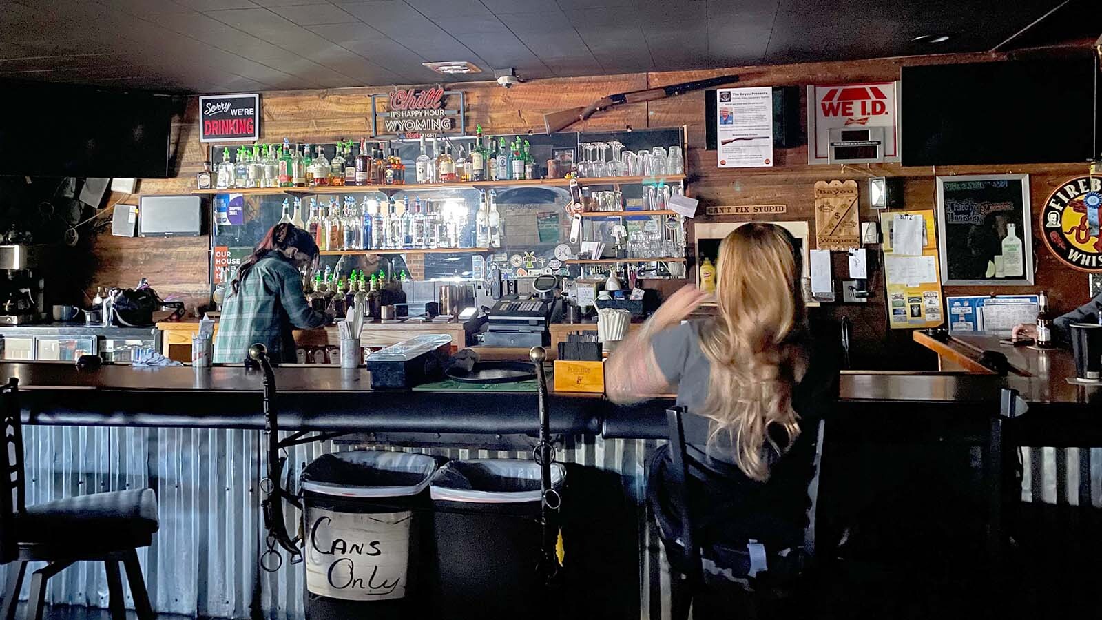 Rae drinks vodka Red Bull at the bar with the lights out at the Bayou Bar in Mills, Wyoming.