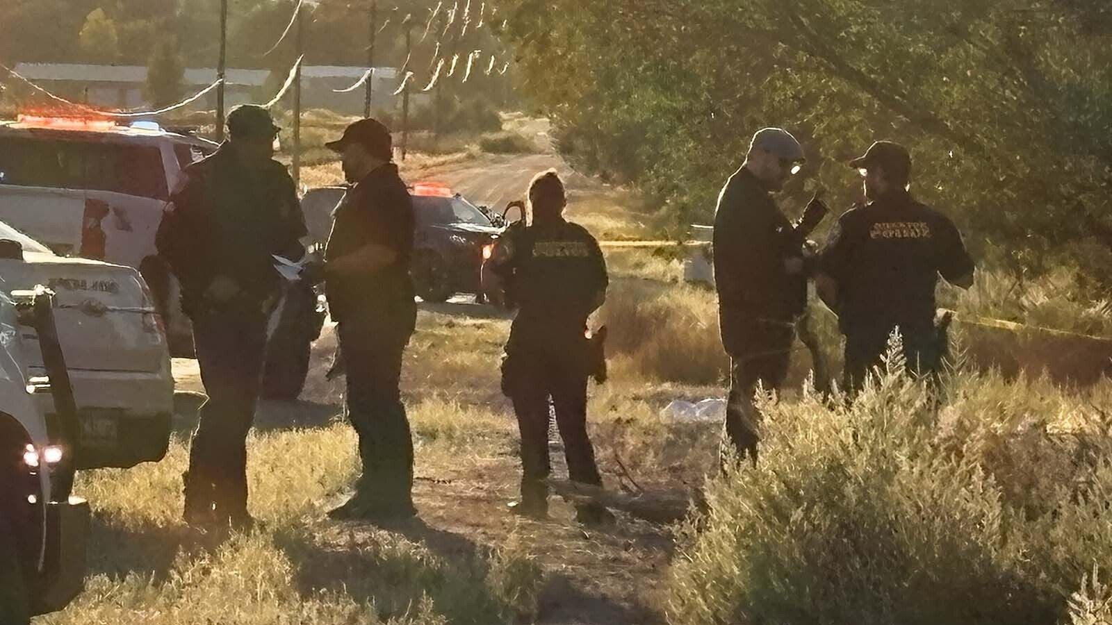 Fremont County Sheriff's Detective Wes Barry (second from right, in a hat) speaks with other investigators on the scene of a death investigation Saturday morning north of Riverton.