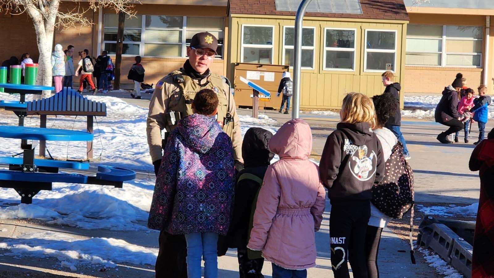 Deputy Miles De Primo hands out stickers to elmentary students in Laramie County