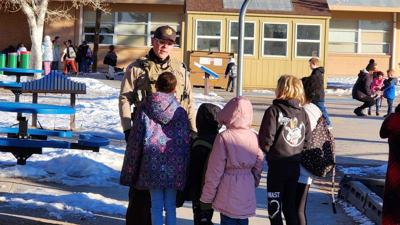 Deputy Miles De Primo hands out stickers to elmentary students in Laramie County