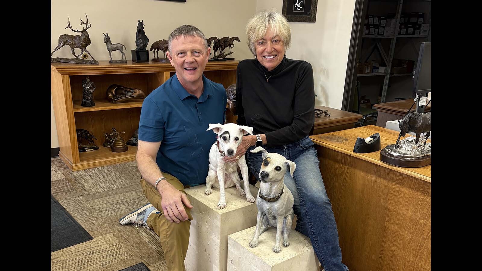 Harvey Deselms and bronze sculpture artist Christine Knapp show off the real and bronze versions of Dot, Deselms’ Jack Russell terrier. The bronze is in front.