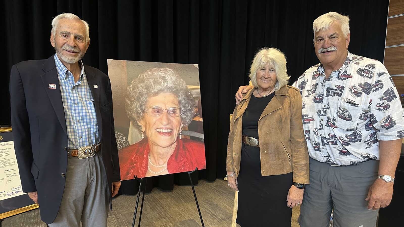 Eli Bebout, from left, Ruby Calvert and Nick Bebout stand with a portrait of their mother, Dessie A. Bebout, during the dedication of the Shoshoni U. S. Post Office in their mother’s honor on Wednesday at the Shoshoni School.