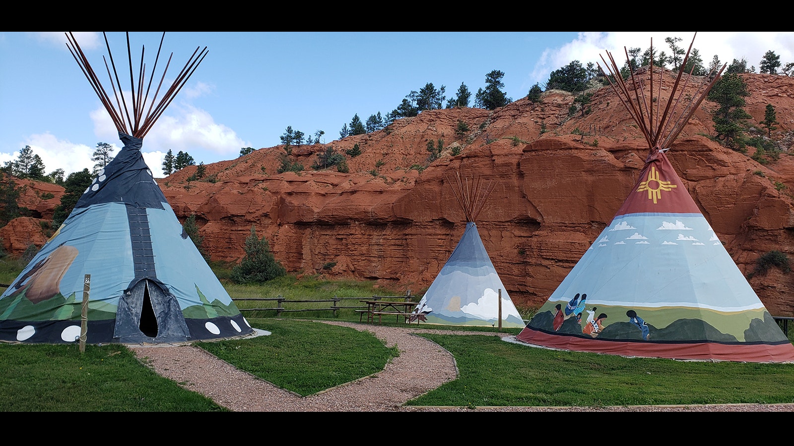 Red canyon walls make a dramatic backdrop for the teepees at the Devils Tower KOA. Scenes are painted on the teepee depicting American Indian legends about the tower, which was known to them as Bear Lodge.