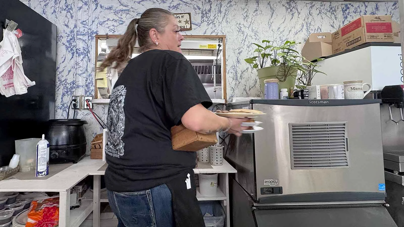 Kendra Scott picks up plates full of food as the cooks at Diamond Horseshoe Café bust out a busy Sunday morning breakfast service.