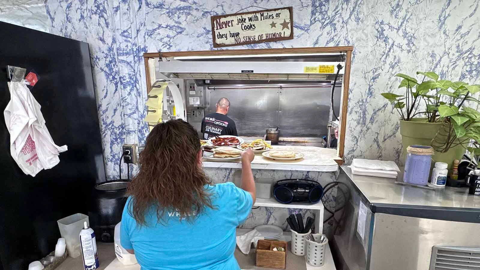 Chanci Roberts picks up plates full of food as the cooks at Diamond Horseshoe Café bust out a busy Sunday morning breakfast service.