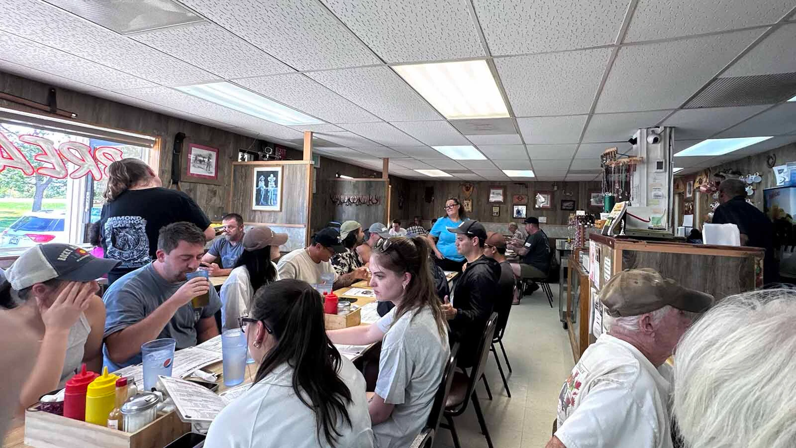 The Diamond Horseshoe Café in south Cheyenne is packed for breakfast on Sunday morning. Working the room are servers Kendra Scott, left standing, and Chanci Roberts, back.