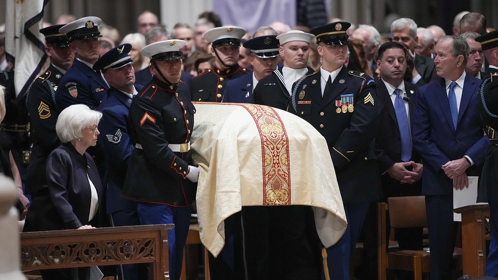 Lynne Cheney, left, and former President George W. Bush, right, stand as U.S. military body bearers carry the casket containing the remains of her husband, former U.S. Vice President Dick Cheney, at his funeral service at the National Cathedral on Nov. 20, 2025, in Washington, D.C.