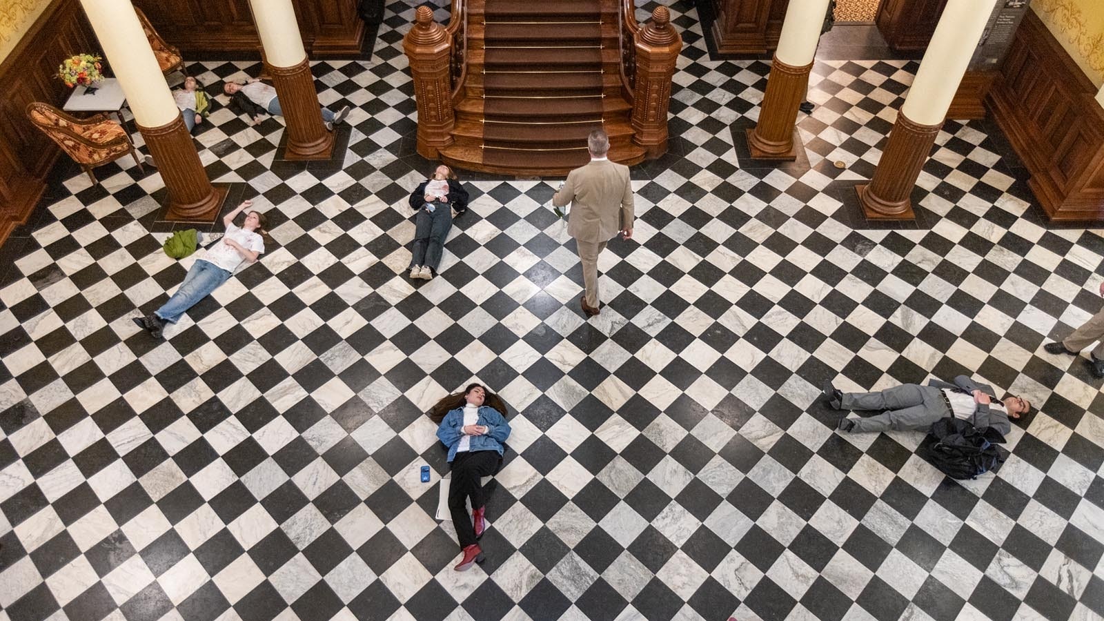 About 20 protesters made up to resemble shooting victims lay on the floor of the Wyoming Capitol on Monday afternoon, Feb. 24, 2025, over a bill that would ban gun-free zones.