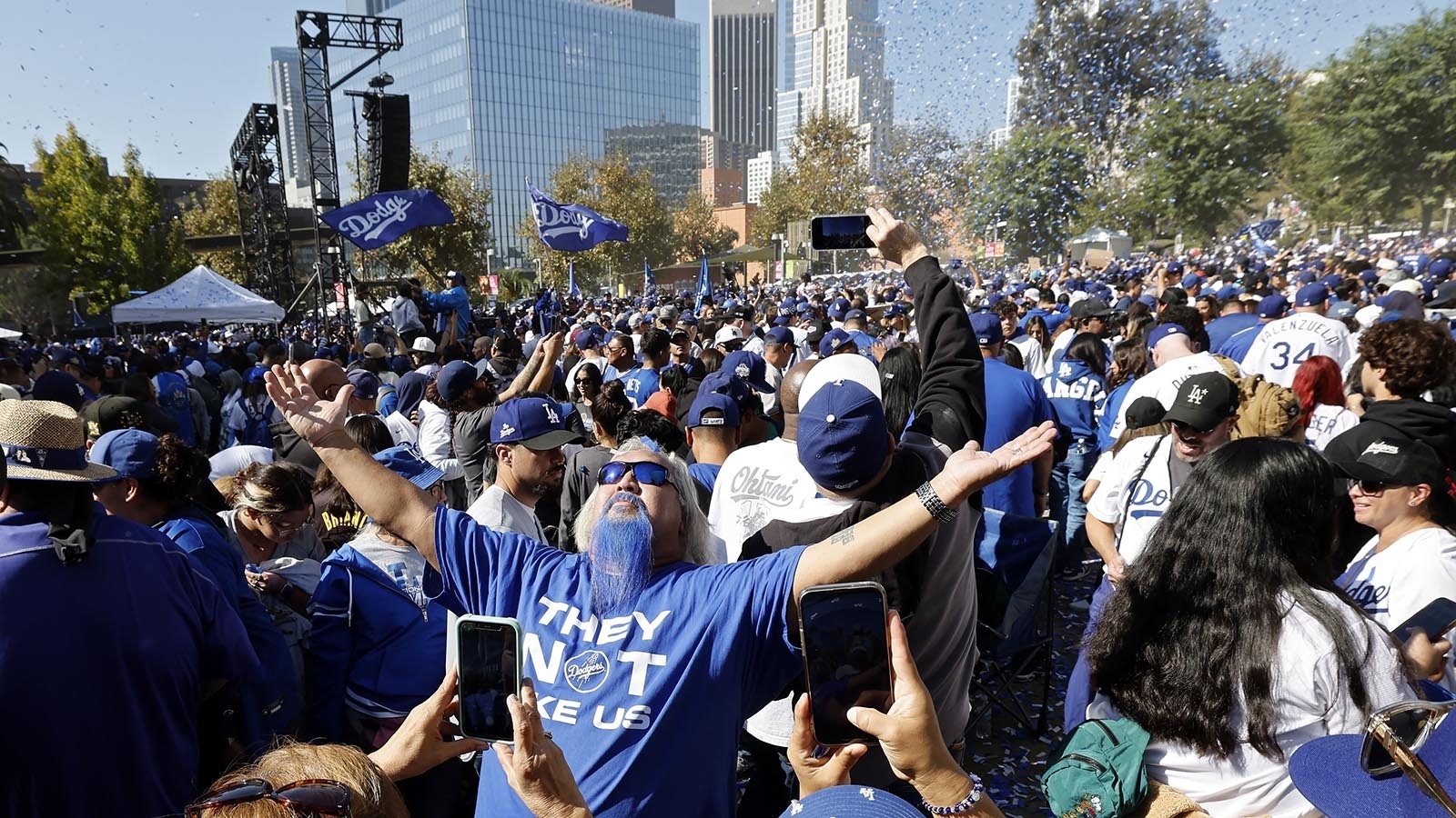 Fans celebrate along the parade route as the team passes by on buses during the Los Angeles Dodgers 2024 World Series Championship parade on Nov. 1, 2024, in Los Angeles, California.