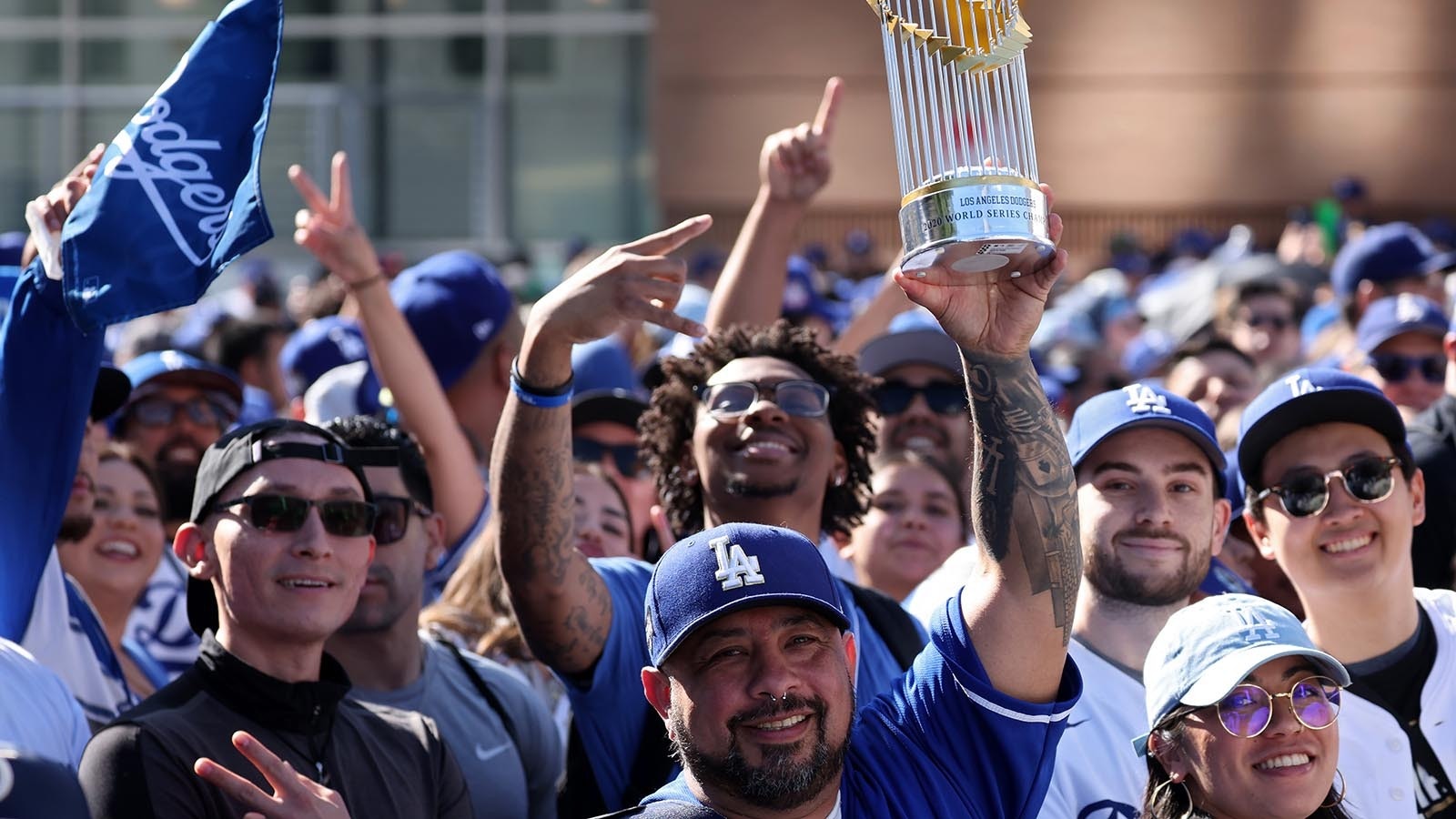 A fan holds a miniature Commissioners' Trophy up along the route during the 2024 World Series Championship parade Nov. 01, 2024, in Los Angeles, California.