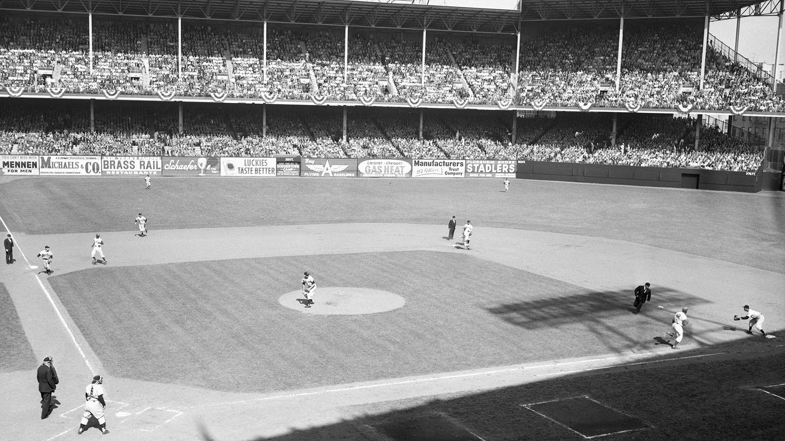 Ebbets Field during the round-the-horn double play that broke up a Dodgers threat in the first inning of the second World Series game in 1956. Robinson hit to Billy Martin at third, who threw to Coleman at second, forcing Gillman out. The relay to Collins was in time to double Robinson who is shown heading for the bag at right as Collins takes Coleman's throw. Yankee catcher Berra is following the play at left.