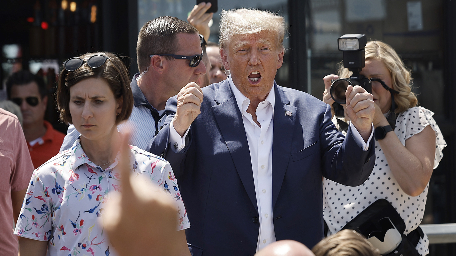 Former President Donald Trump interacts with supporters.