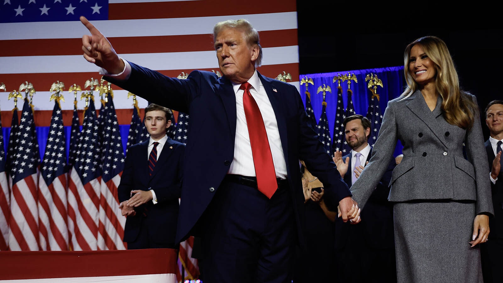 Donald Trump points to supporters with former first lady Melania Trump during an election night event at the Palm Beach Convention Center on Nov. 6, 2024, in West Palm Beach, Florida.