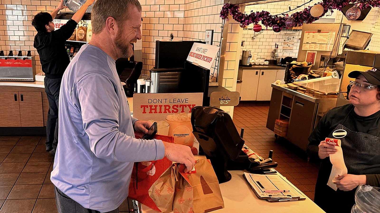 Mike Aumiller picks up a DoorDash order at the Lincolway Arby's outlet in Cheyenne on Sunday. Aumiller said his wife delivers DoorDash during the week, and he does it on weekends to make some extra money.