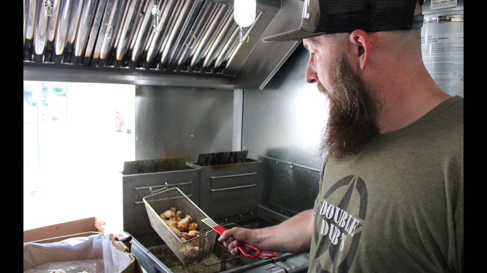 Chris Chamberlain helps cook wings on Friday.