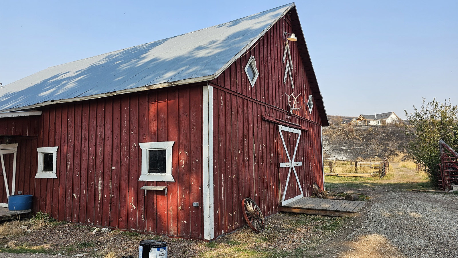 The Double Rafter's red barn near Parkman, Wyoming, was raised in 1890. In the distance is the new home Chelsie and Marcus Warner are building. The burn scars show how close the ranch came to being consumed by the Elk Fire.