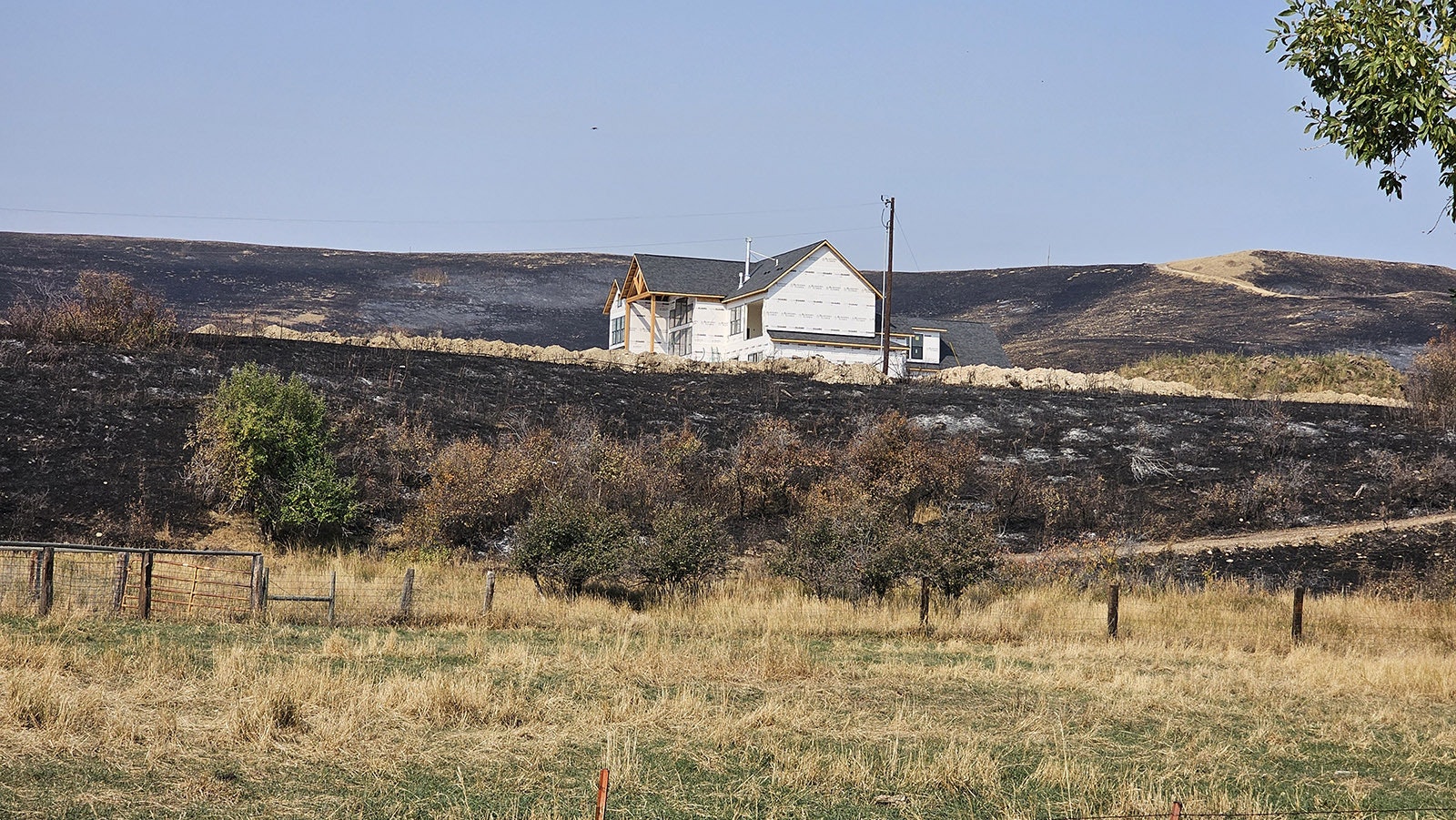 The Elk Fire was within a few feet of this home under construction near Parkman, Wyoming, and in the path of the Elk Fire. A dirt berm, as well as efforts by firefighters helped save it.