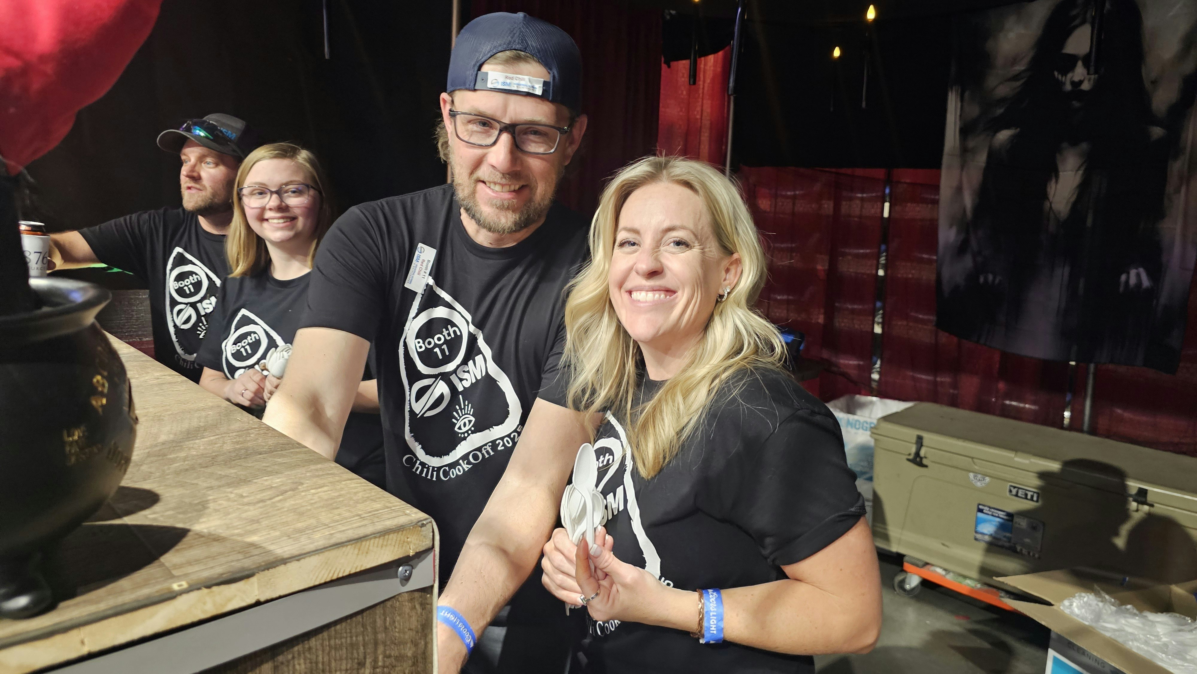 Lindsey Robinson, right, smiles as she hands out spoons at the Industrial Screen and Maintenance booth during the API chili in Casper. Robinson is among oil and gas companies hoping an energy boom is around the corner, but says it is still wait and see.