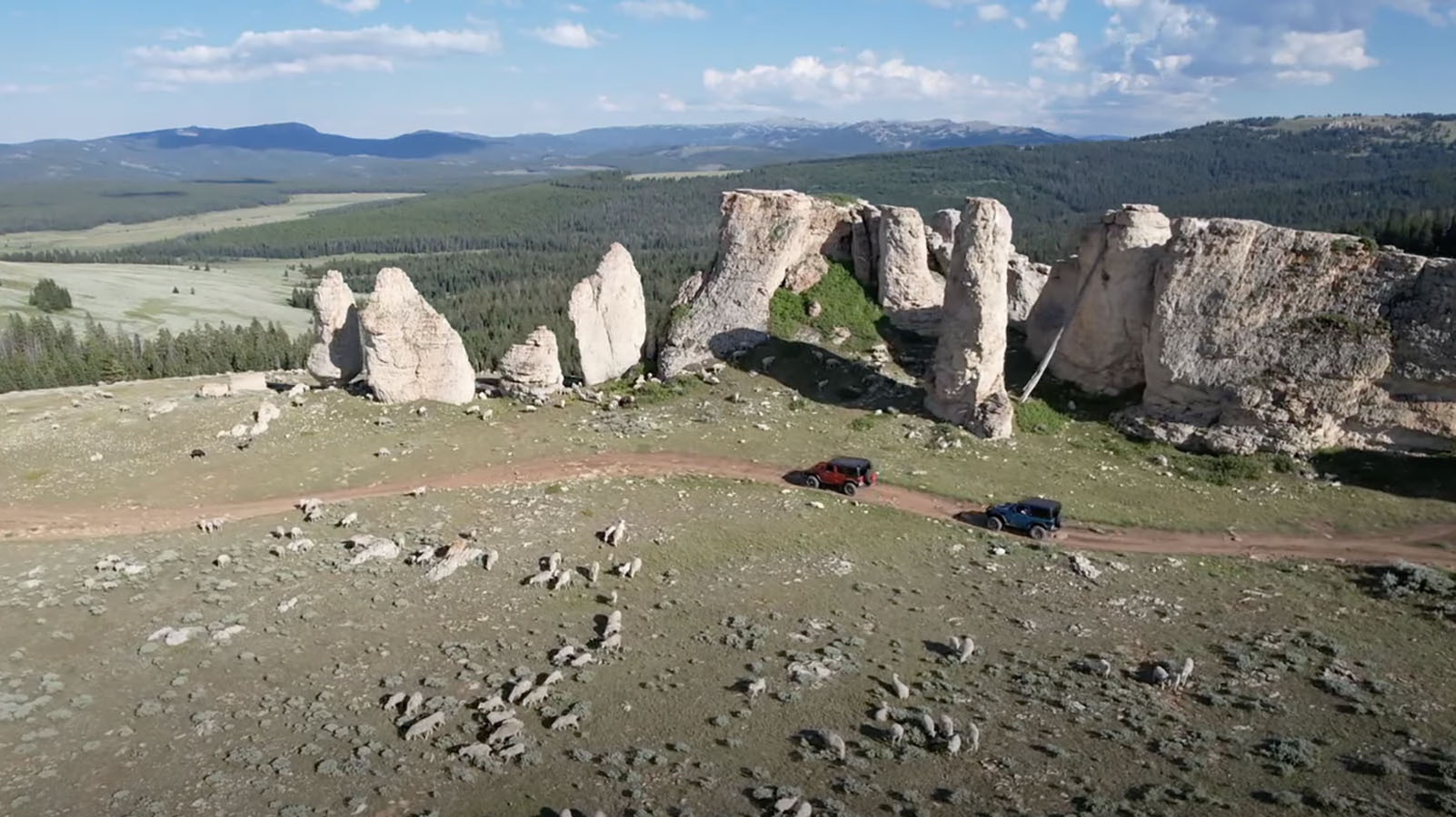 Drone shot of Wyoming Jeepers passing by sheep and some interesting rock formations.
