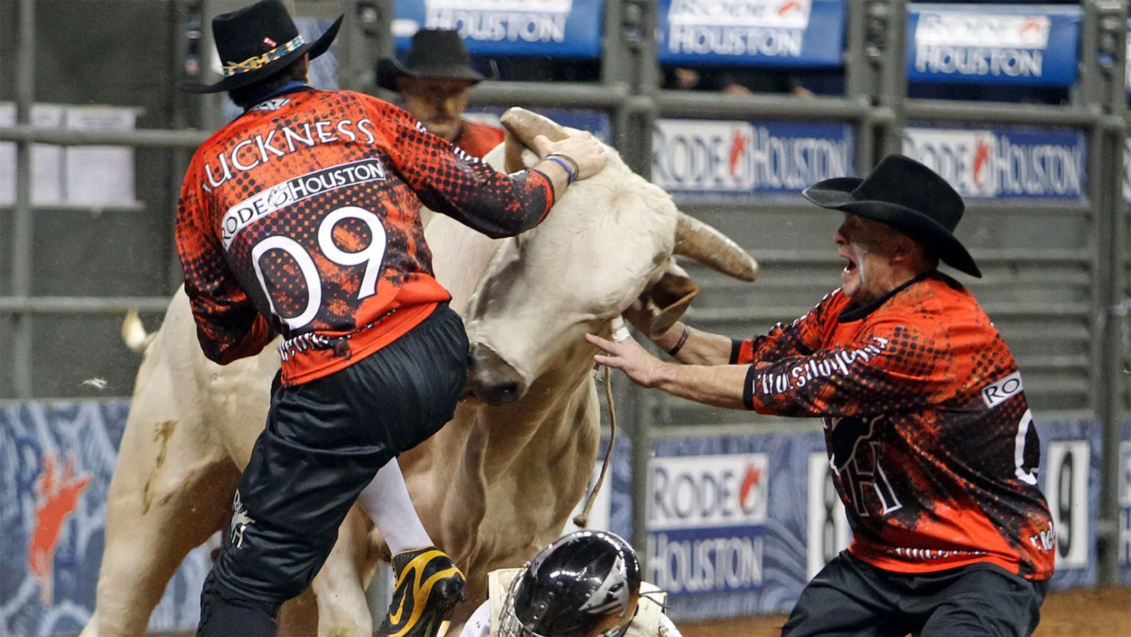 Rodeo bullfighters Dusty Tuckness, left, and Cory Wall keep a bull away from Sonny Murphy after he finished his ride during the bull riding event at the Houston Livestock Show and Rodeo in Reliant Stadium on March 11, 2012, in Houston.