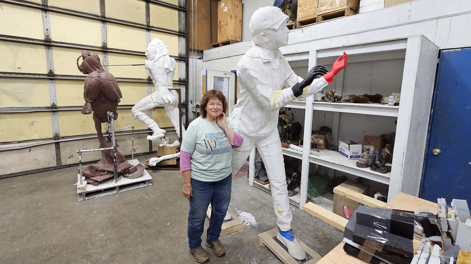Beverly Paddleton poses next to a statue she's working on at Eagle Bronze in Lander.