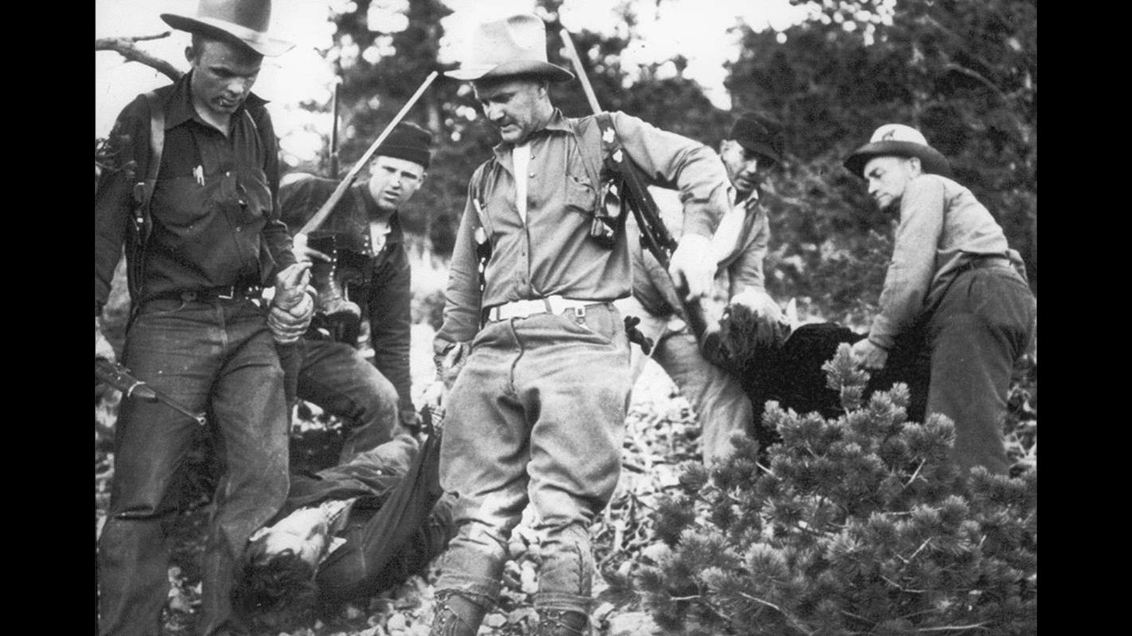 Ignoring warnings, two posse members approached Durand's rocky hideout and he shot them dead--the bandit's third and fourth victims. Here, officers carry out the bodies the next day, by which time the fugitive had fled again.