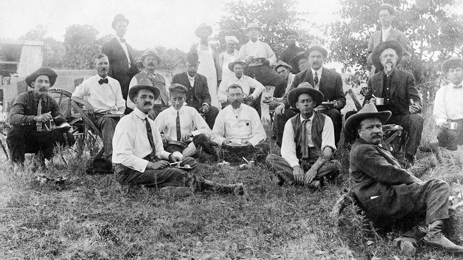 Biffalo Bill, sitting right, gathers with others for a meal in 1912.