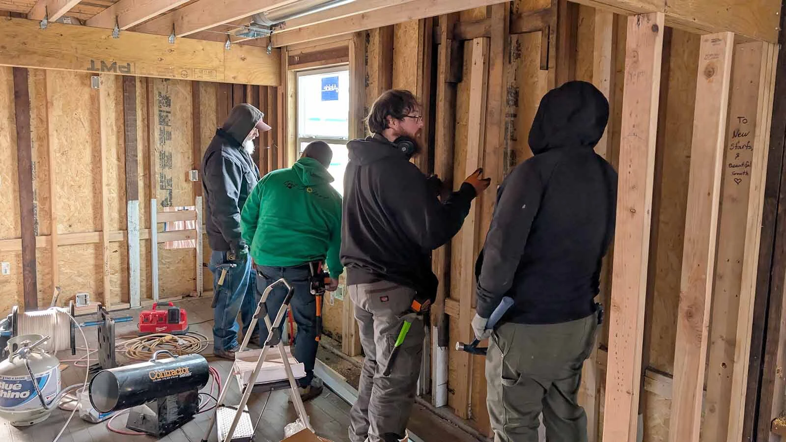 Electricians Ryan Terry, Manuel Sanchez, Luke Frohnapfel and Randolph Page work on a Habitat for Humanity home.