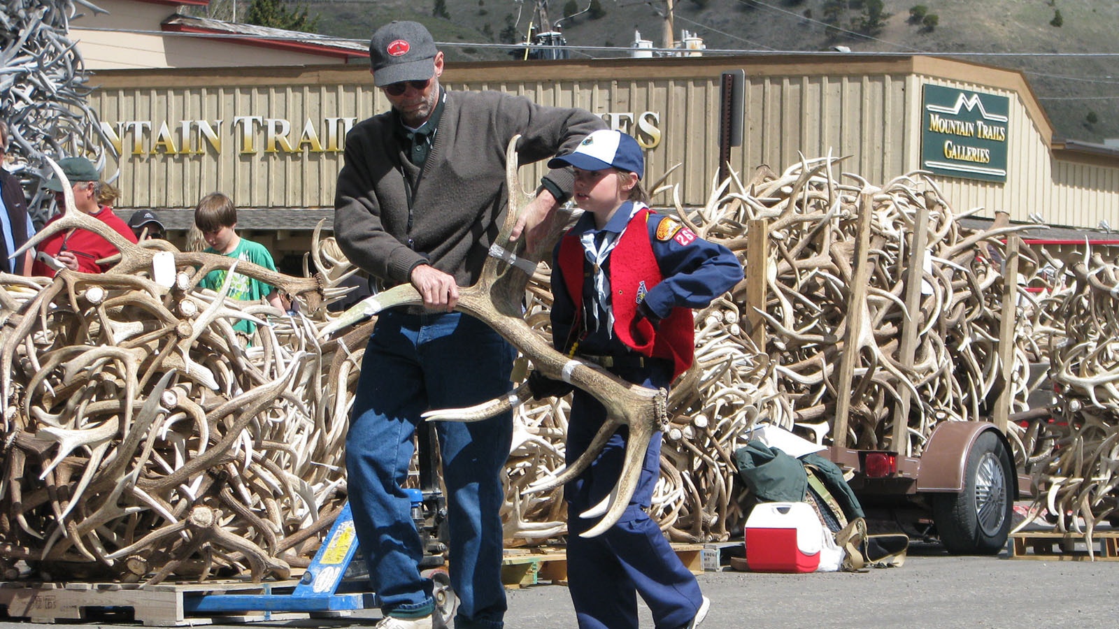 A Cub Scout carries a matched set of antlers to the auction stage at a past ElkFest. Workers who prepare the antlers for auction try to match sets whenever possible as they bring in more money per pound.