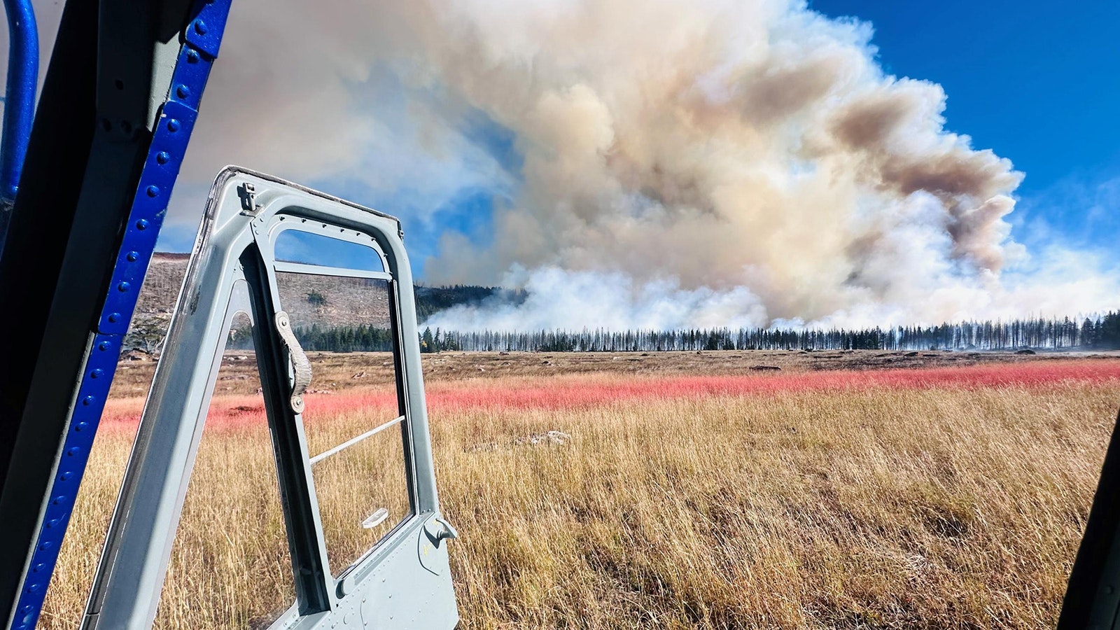 A brightly colored line of fire retardant is placed to help curb the spread of the Elk Fire.,