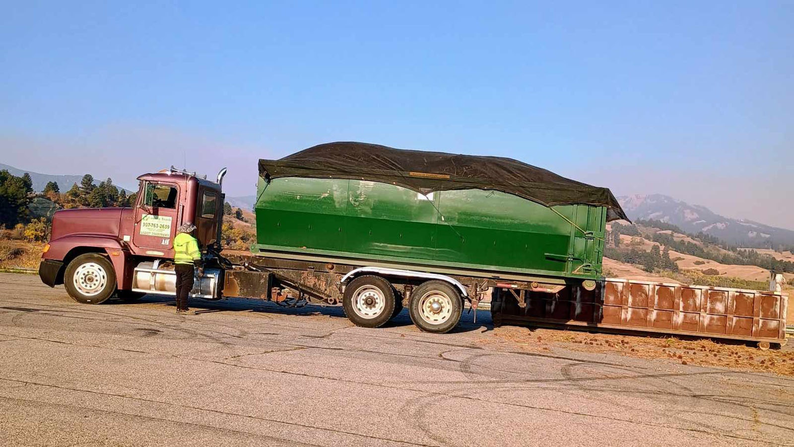 Technically, the roll-off bin was overfull, but the driver was able to completely tarp the load and, given the situation, let it roll anyway.