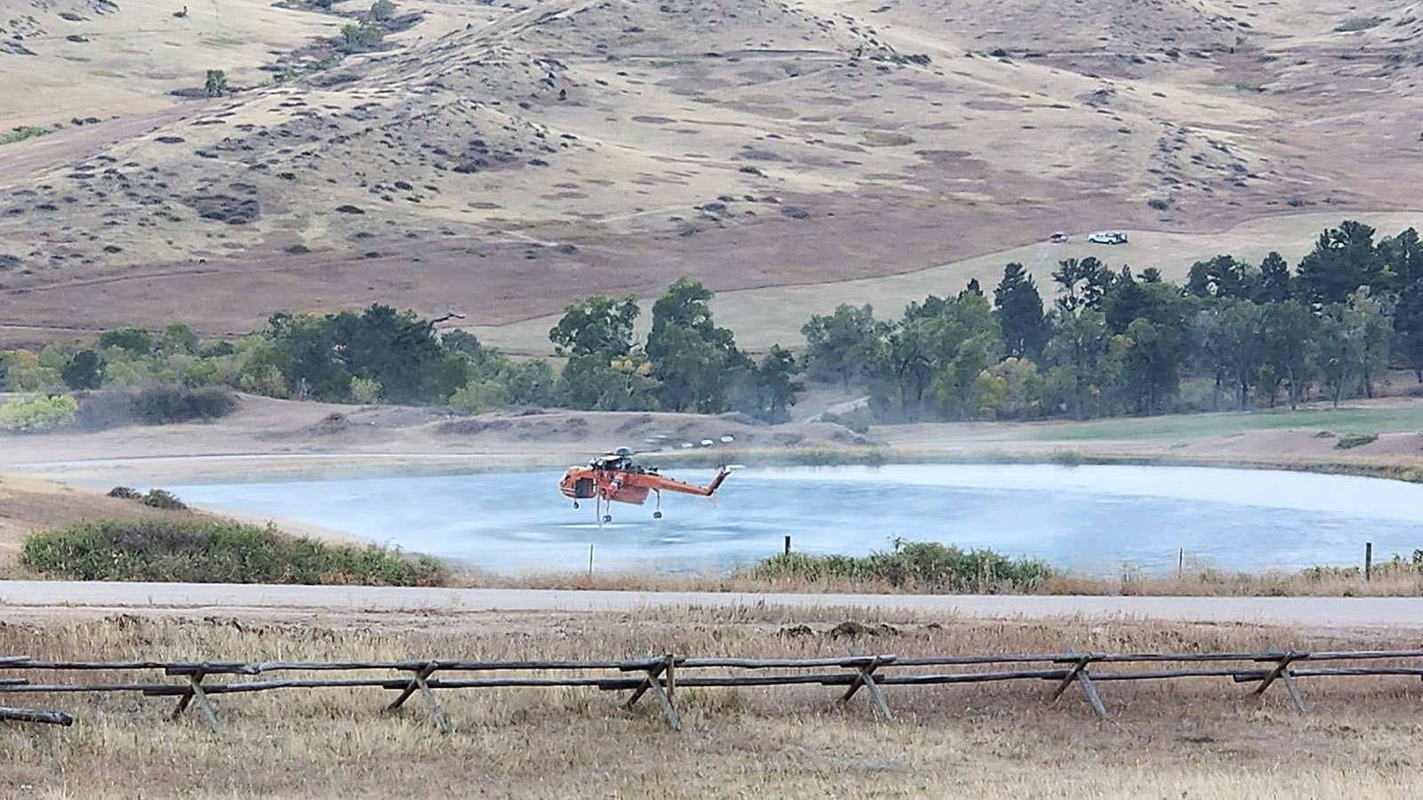 A helicopter refills its water bucket to drop on the Elk Fire.