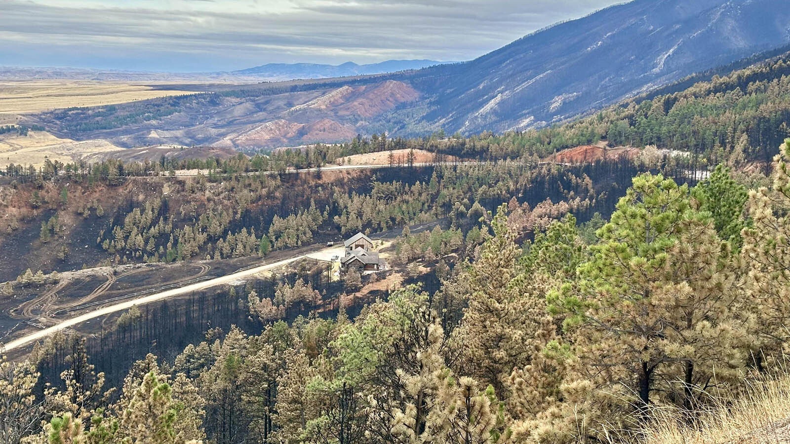 View from Highway 14 shows large swaths of land burned by the Elk Fire, and a home that wasn't.